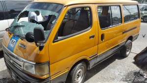 The damaged minibus in front of the store