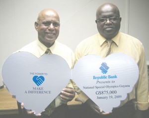 Chairman of the National Special Olympics of Guyana, Affeeze Khan (left) and National Director, Wilton Spencer show off the creative Republic Bank cheque yesterday at Kaieteur News.