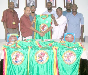 Managing Director of Bounty Farm Limited, Patrick DeGroot (left, forefront) presents one of the uniforms to Bounty Colts’ Captain, Kayode Murray yesterday while other players and club representatives look on. Head Coach, Phillip George is at right.