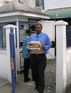 An agent clears out his stuff out of the now closed CLICO building on Lamaha Street