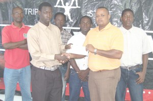  Ansa Mc Al Trading Marketing Manager Troy Cadogan (2nd right) presenting the winning cheque to Buxton United’s defender, Colwin Barnwell in the presence fellow team members and coach Linden France (left).      