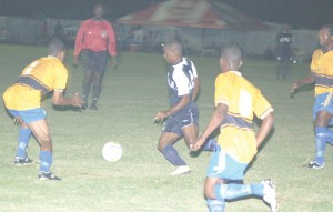 Alpha’s Edison Gomes (3rd right) maneuvers his way through the Western Tigers defence in their CPL clash on Monday night. (Franklin Wilson photo) 