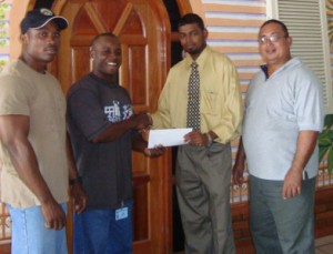 Mervin Moses (2nd left) is all smiles as he collects the donation  from Accountant of Hotel Tower International Prem Dwarka.  Others in photo are Peter Green (right) and Randolph Morgan.    