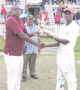 Man-of-the-Match Eon Hooper (right) collects his award from GTM’s representative Mr. Jones after his unbeaten 71 for Berbice, at Blairmont, yesterday.