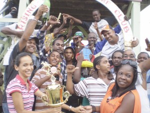 A representative of the Crawford Stable (right) is all smiles as she receives the winning trophy for one of Vanessa’s wins.  