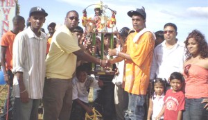 Banks manager Mortimer Stewart presents the winning trophy in the two yr old event to Nazrudeen Mohammed Junior of the Jumbo Jet.