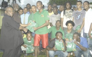 Managing Director of Brans Security Service Harold Bransford (left) presents one of the jerseys to Captain of the National Under-19 team Lancelot Adonis last Thursday.