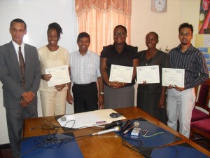 Teachers display their certificates in the presence of  Mr Dennis Moses (at left) and Minister Baksh (third from left)