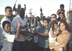 Directors Gansham Singh and Ian John of the NSMTC presents the Guyenterprise trophy to Rose Mohammed of the Jumbo Jet Stables.