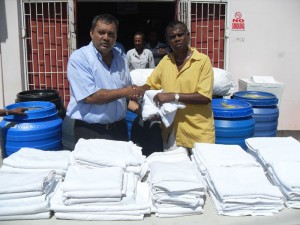 Chandrika Manharat (right) makes the donation to Michael Khan