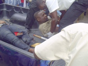 The driver Metanga Cameron is assisted from the back of a pick-up.