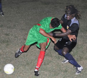 Battling for supremacy!!! GDF’s Sheik Kamal  (left) and Alpha’s Abassi McPherson fight for possession. (Franklin Wilson photo)   