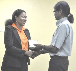 THAG President Renata Chuck-A-Sang presents an award to Yog Mahadeo of GT&T for the telephone company’s support for the Association. The Award was presented at the Annual General Meeting of THAG on Wednesday.  