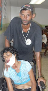 An injured Samantha at the Georgetown hospital yesterday being supported by Rupran Sugrim 