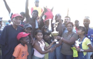 Mrs. Naljit of the GHRA presents the winning trophy in the feature C class event to young Ann Singh of the Customs racing stable. 