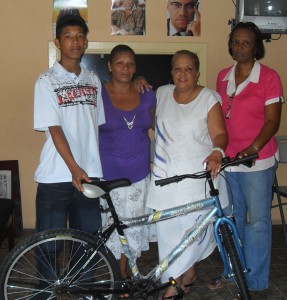 Sean Thomas poses with his new bicycle  in the presence of his mother Shirley, Sister H  and counselor Jennifer Thomside