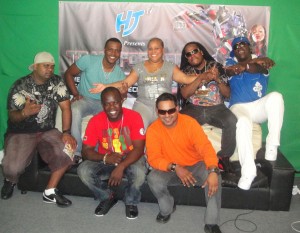  Ready to dish the vibes in Guyana: De Hunter, Kevin Lyttle,  Denise Belfon, Ghetto Flex and Jamesy P. Missing is Terry Gajraj.  Sitting are promoter Kenston Harry, left,  and ‘D’ Hitman