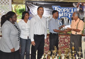 Tropical Mist Brand Manager Errol Nelson (2nd right) hands over the sponsorship cheque  to President of the GLTA Christopher Ram in the presence of officials yesterday.