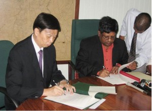 Minister of Finance, Dr. Ashni Singh, and Chinese Ambassador to Guyana, Zhang Jungao, sign the economic and technical cooperation agreement that will see Guyana benefitting from a $1.2B grant 