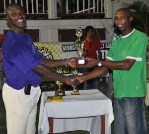 Man-of-the-Match Neil Barry receives his prize from Competitions Chairman Shawn Massiah yesterday, at the DCC ground