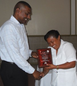 Health Worker of the Year  Corina Williams receives her accolade  from CMO Dr Shamdeo Persaud