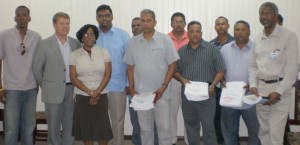 Contractors with housing officials and IDB Country Representative, Marco Nicola, yesterday.