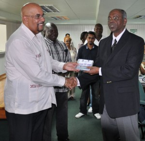 Dr Richard Van-West Charles (left) hands over the digital records to the Speaker of the National Assembly Ralph Ramkarran