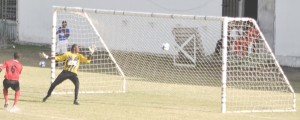 Alpha’s goalkeeper Ronson Williams (2nd left) agonizingly watches the ball settle in the back of the nets compliments of a well taken shot by Elias Afonsoewa in the 12th minute. Defender Anthony Harding is at left. (Franklin Wilson photo) 