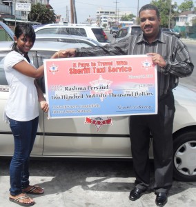 The owner, Jerald Toovey, hands over the cheque to Rashma Persaud 