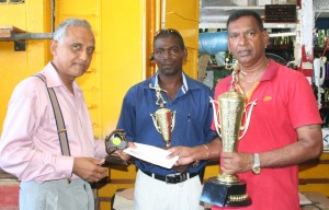 Ramesh Sunich (right) of the Trophy Stall at Bourda Market presents the sponsorship cheque and trophies to GLTA President Christopher Ram.