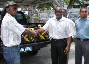 Deputy Permanent Secretary of the Ministry of Agriculture, George Jervis (center) hands over three pumps to a representative of Region Seven. Looking on at right at the Agri Ministry’s officials who are part of the task force tackling problems from the El Nino conditions.