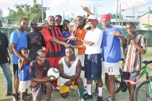 Flamingo Captain Shem Porter receives the winning trophy from co-sponsor Phillip Squires (third right standing) in the presence of team-mates yesterday. 