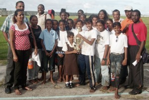 Mc Gillivary captain Rohini Doodnauth receives the winning trophy from Pooja Ramnauth, while her team-mates look on.