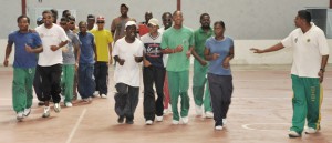 Coach Mangru (right) conducts a jogging session with the National Blind Cricket squad at the National Gymnasium yesterday. 