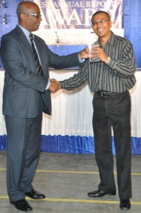  Robert McRae (left) of Ram & McRae presents the award to DDL General Manager, Loris Nathoo