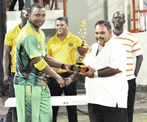 Captain of the Guyana Warriors Chris Barnwell (left) collects the winning trophy from President of the Guyana Cricket Board Drubahadur