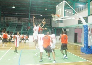 OH NO! Ravens’ guard, Akeem ‘The Dream’ Kanhai (with ball) skilfully evades a soaring Earl O’Neal to finish an awesome left-handed lay-up Saturday night at the Cliff Anderson Sports Hall.