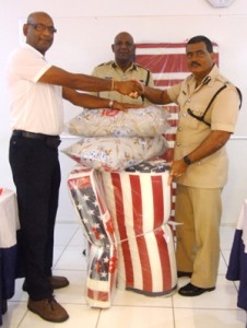 Assistant Commissioner David Ramnarine receives the symbolic mattresses and pillows from Mohamed Najab.