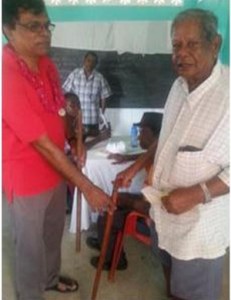 Dr Mahadeo gives a cane to a grateful senior.