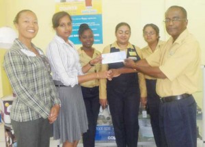 Mr. Stanley McKenzie, Branch Manager hands over sponsorship cheque to Alisa Moonsee in the presence of other staff members and Cosmatia Lindee (left). 