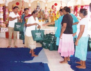  Extreme left: Businessman Indarjit Sukdeo shares out the hampers to many of the mothers present.