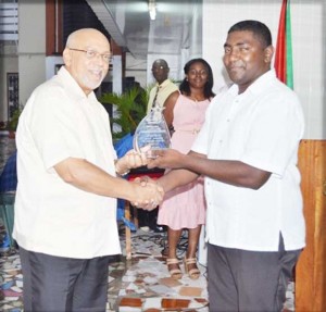 President Donald Ramotar receives a token for his work in fostering relations between Guyana and Cuba from the Guyana-Cuba Friendship Association