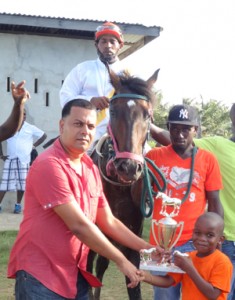 A representative of Banks DIH presents the winning G class trophy for Monsoon’s victory.