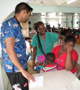 Dr. Candace Cummings and student, Melvin Parasram, examine patient complaining about throat aches.