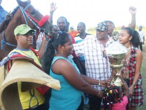 Yasmin Shariff and the rest of the Shariff clan are all smiles as she receives the winning trophy from Mrs. Richmond. 