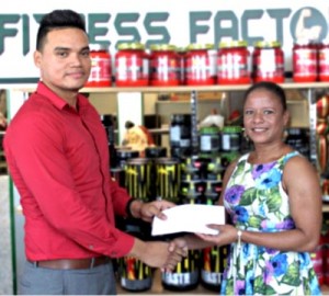 Julian Neblett of Gizmos and Gadgets hands over a cheque to Flex Night Inc. Special Assistant Fiona Harris.