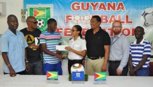 Tiffany Herbert hands over the ticket to Domini Garnett in the presence of from right, Wayne Francois, Stuart May, Kashif Muhammad, James Herbert and Garnett’s father, Mark.