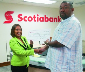 RHTYSC Secretary/CEO Hilbert Foster receives the sponsorship cheque from Ms. Jennifer Cipriani, Scotia Bank Marketing Manager.