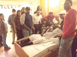Christopher Robinson surrounded by family members at the hospital where he is currently a patient