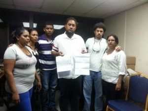 Roy Couchman holds up the documents to prove the legitimacy of the dead man's operations. Couchman's younger brother Gary stands right with the deceased man's wife. His son stands left of Roy with other relatives 